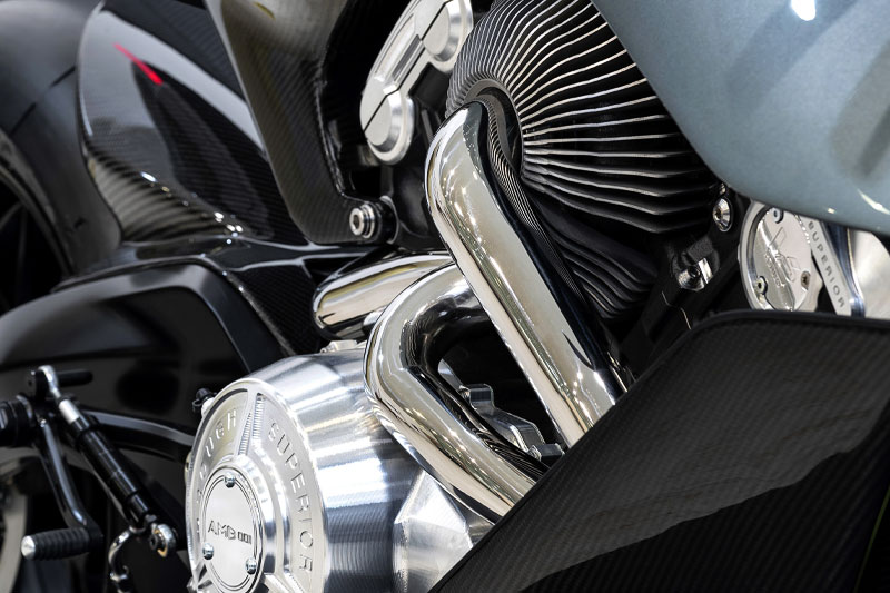 Brough Superior | ブラフシューペリア : AMB 001。英国の名門アストンマーティンとの共演から生まれた限定モデル。ターボ搭載Vツインとカーボンボディが極限の機能美を体現する。